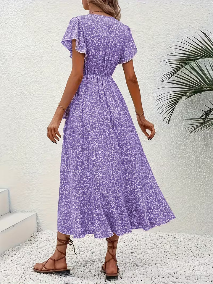 Frau spaziert im bauchumspielenden, fließenden Sommer Maxikleid mit Muster und Wickeldetail.