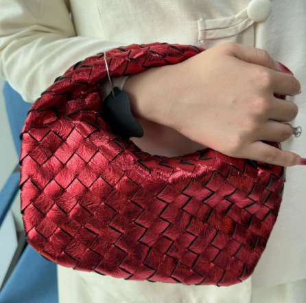 Luxuriöse Damen-Schultertasche mit Metallic-Effekt und kunstvollem Geflecht.