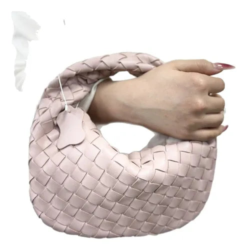 Nahaufnahme der geflochtenen Metallic-Struktur und des Verschlusses der Damen-Handtasche.