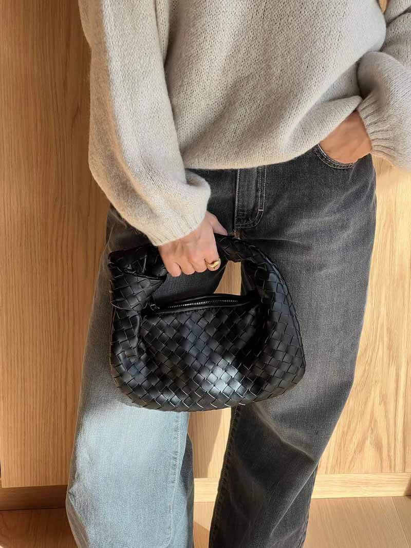Detailaufnahme der geflochtenen Struktur dieser luxuriösen Damen-Handtasche, Metallic-Glanz.