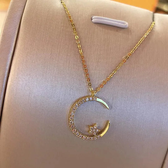 Nahaufnahme einer goldplattierten Damen Halskette mit funkelndem Mond- und Stern-Anhänger. Eleganter Schmuck.