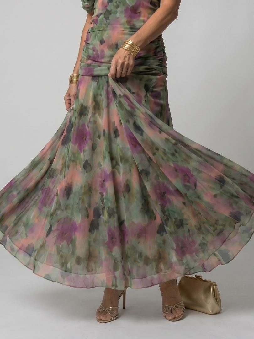 Seitenansicht: Frau trägt ein fließendes Off-Shoulder Midikleid, zeigt die elegante Passform und Länge.
