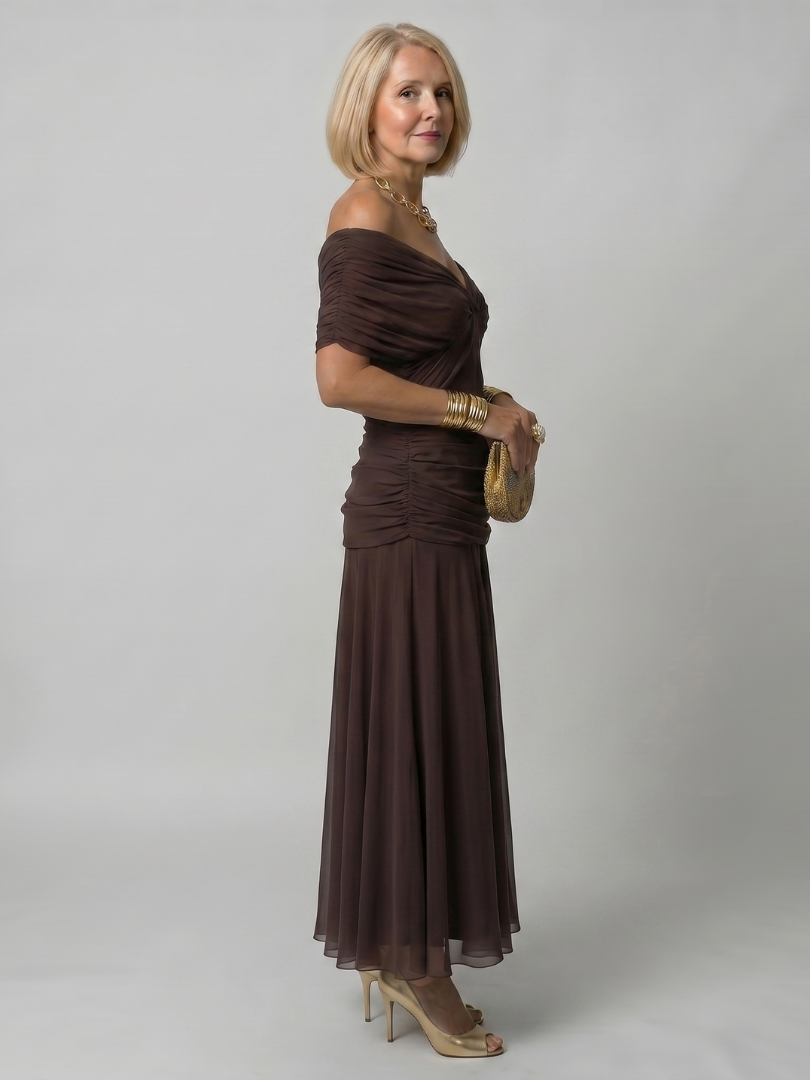 Off-Shoulder Damenkleid in lebendigem Blau, kombiniert mit Sandalen und einer stylischen Handtasche.