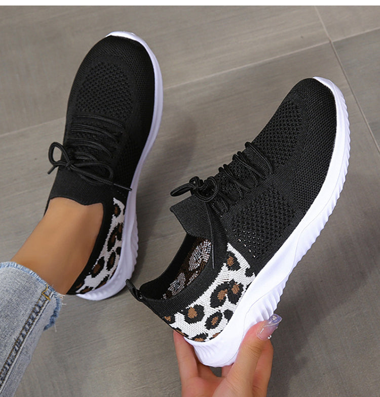 Damen trägt modische Leopardenmuster-Sneaker, bequeme Freizeitschuhe für den Frühling.