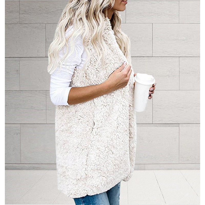 Modell trägt elegante, ärmellose Damen Strickjacke mit Plüschkapuze; perfekter, warmer Cardigan für Winter.