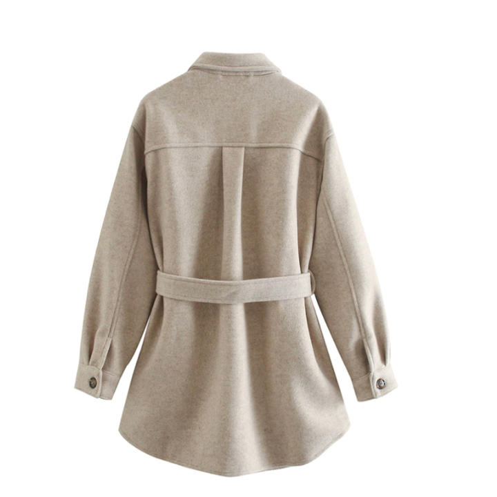 Dame trägt eleganten beigen Frühjahrsmantel mit Gürtel. Stilvoller Übergangs-Look für Frauen.