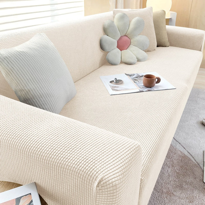Dehnbare Sofahusse in Grau; elastischer Sofabezug für optimalen Schutz und neuen Stil im Wohnzimmer.