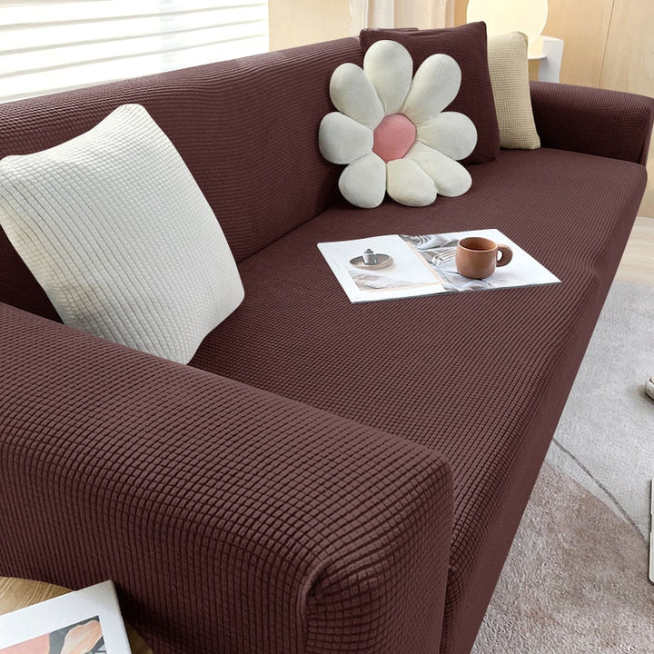 Elegante Sofahusse in Beige; elastischer Bezug für stilvolle Wohnzimmer Dekoration.