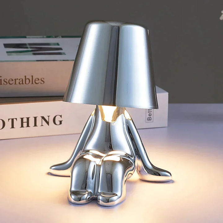 Dimmbare LED Tischlampe auf einem Beistelltisch. Schafft warmes, gemütliches Stimmungslicht.