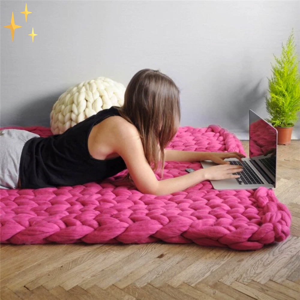 Kind kuschelt sich in eine DIY Decke aus weichem Chunky XL Wollgarn. Gemütliche Handarbeit für Zuhause.