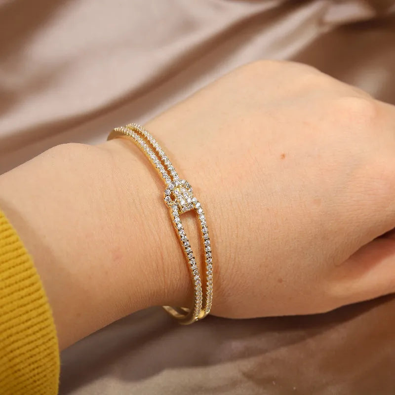 Zeitloser Damen Armreif: elegante Kristalle und ein edler Goldknoten als stilvolles Accessoire.