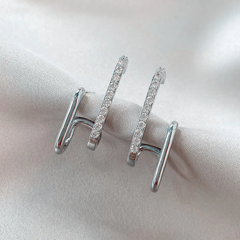 Funkelnde Damen Ohrstecker aus Kristall mit Krallenfassung, die einen stylischen Illusion-Effekt erzeugen.