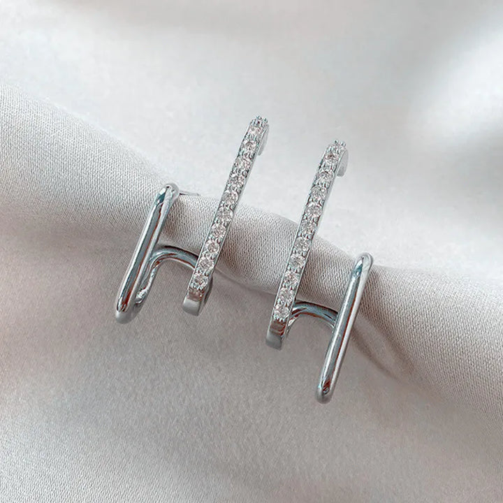 Funkelnde Damen Ohrstecker aus Kristall mit Krallenfassung, die einen stylischen Illusion-Effekt erzeugen.