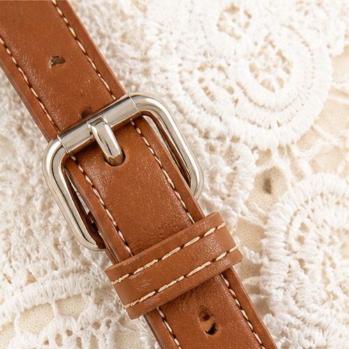 Detailansicht des verstellbaren Schulterriemens der cremeweißen Damen Handtasche mit Spitze.