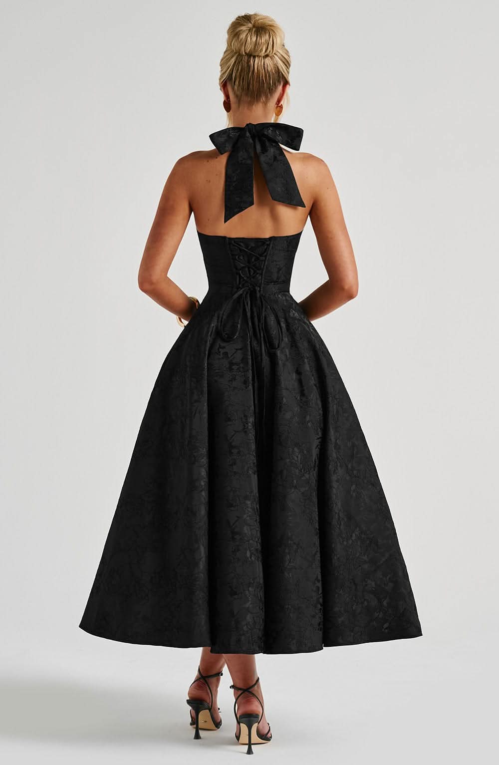 Damen Neckholder Midikleid mit Blumenprint in Bewegung, ein luftiges Sommerkleid im A-Linien-Schnitt für Feiern.