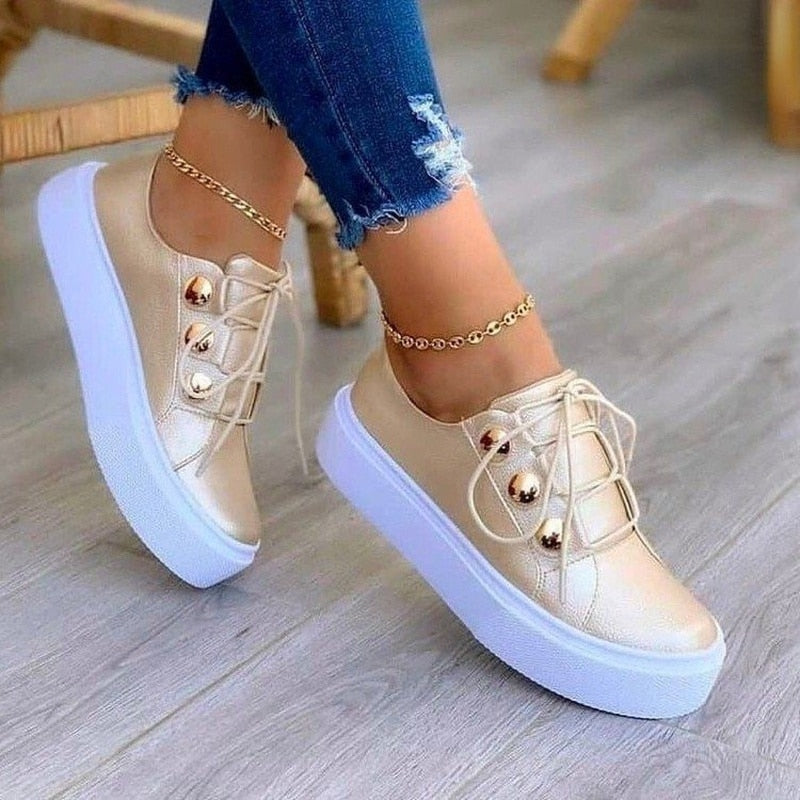 Moderne Damen Sneaker in Gold, kombiniert mit Weiß; stilvolle und bequeme Damenschuhe für aktive Tage.