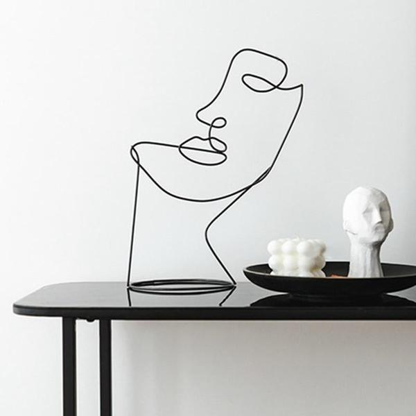 Minimalistische Gesichtsskulptur aus schwarzem Draht, nordisches Design, Einlinien-Kunst für stilvolle Dekoration.