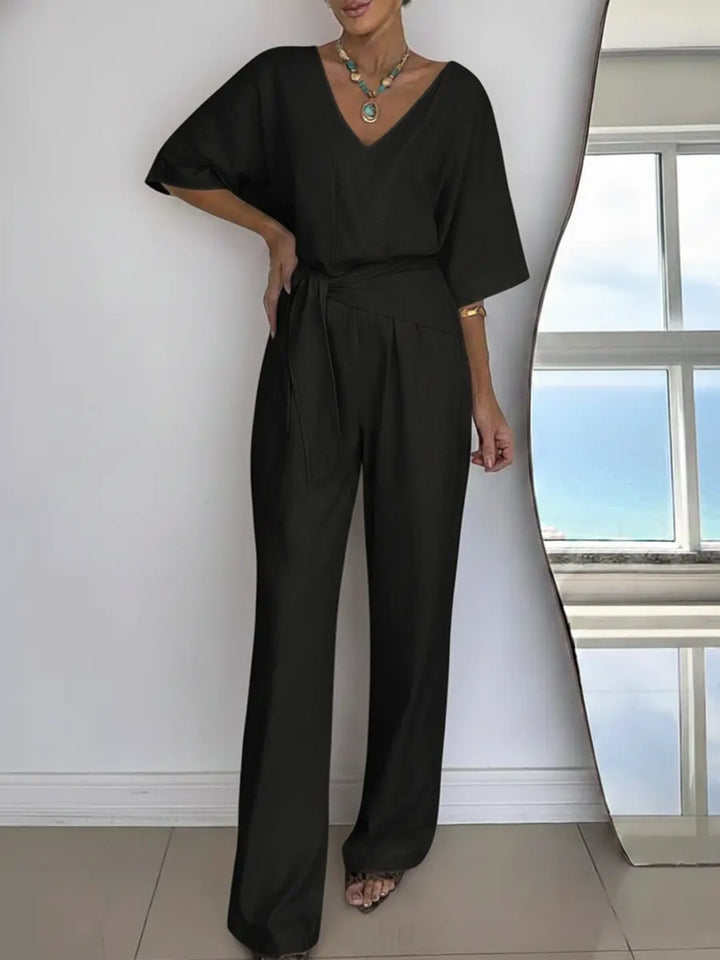 Frau trägt eleganten Damen Jumpsuit, lässig posierend, perfekt für einen stilvollen Sommerlook.