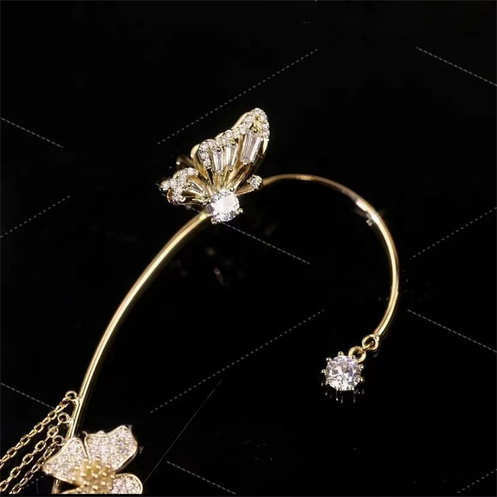 Glitzernder Ohrenclip für Damen, mit funkelnden Steinen besetzt. Eleganter, piercingfreier Ohrschmuck in Gold/Silber.