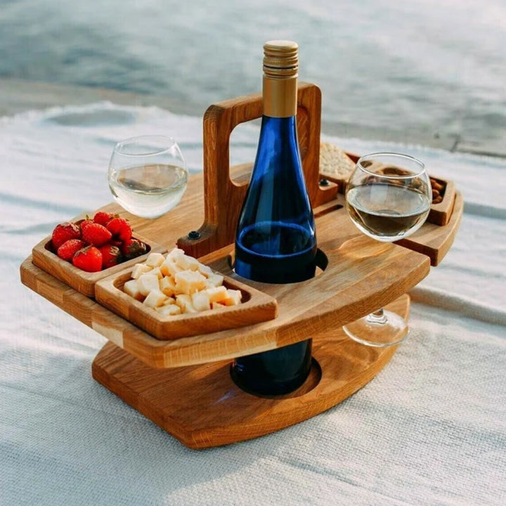 Eleganter tragbarer Picknick-Weintisch aus Holz für Outdoor, mit Glashaltern und Flaschenfach auf Gras.