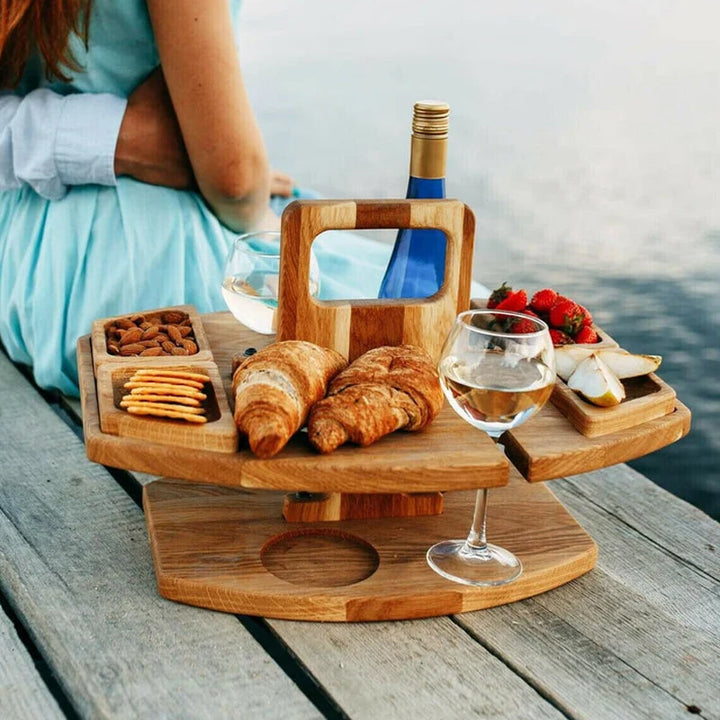 Funktionaler tragbarer Picknick-Weintisch mit zwei Gläsern und Weinflasche in natürlicher Outdoor-Umgebung.