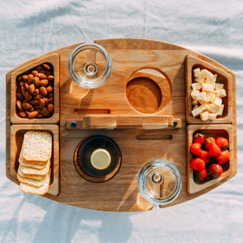 Rustikaler tragbarer Picknick-Weintisch mit Käse, Trauben und Weinflasche, perfekt für Outdoor-Genuss.