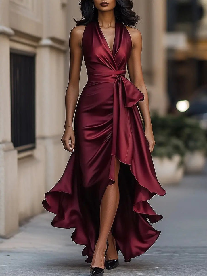 Glamouröses Abendkleid in Bewegung: fließender High-Low Saum & Wickeldetail. Ärmelloses Partykleid für besondere Feste.