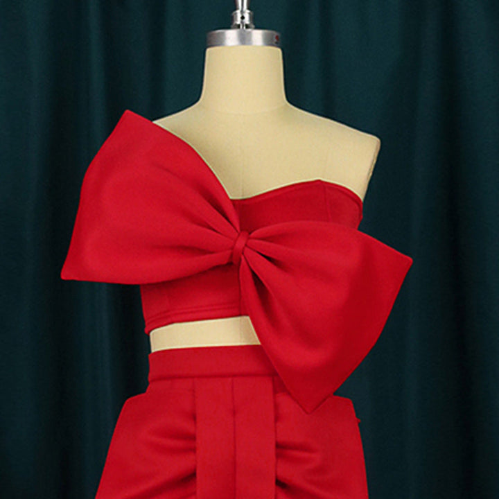 Damenmode: Elegantes Oberteil mit asymmetrischem Schnitt und großer Statement-Schleife, ideal für festliche Events.