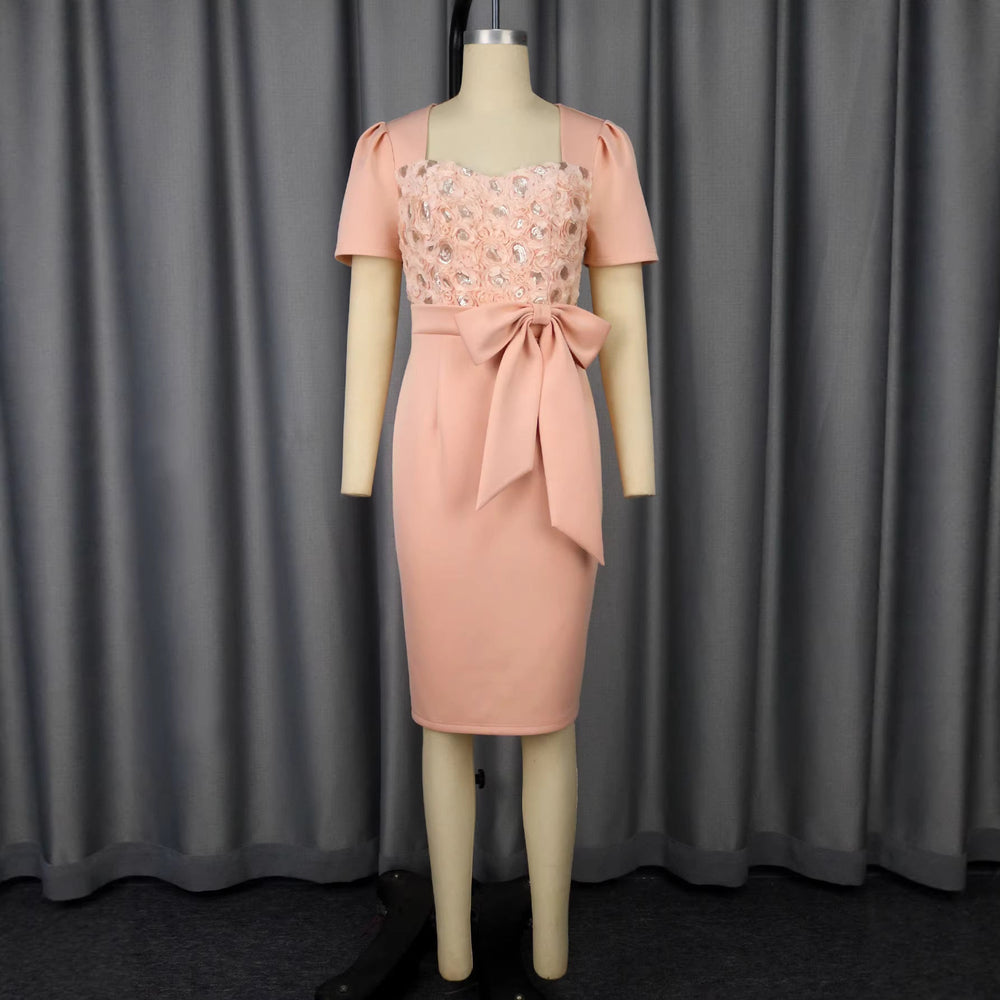 Festliches rosafarbenes Partykleid für Damen, mit zartem Blumenmuster und eleganter Schleife, ideal für Abende und Feiern.