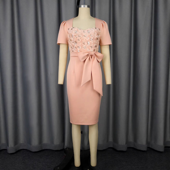 Festliches rosafarbenes Partykleid für Damen, mit zartem Blumenmuster und eleganter Schleife, ideal für Abende und Feiern.