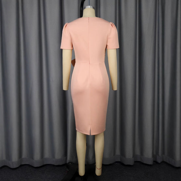 Figurbetontes Cocktailkleid mit detailliertem Blumenmuster und auffälliger Schleife, perfekt für einen eleganten Auftritt.
