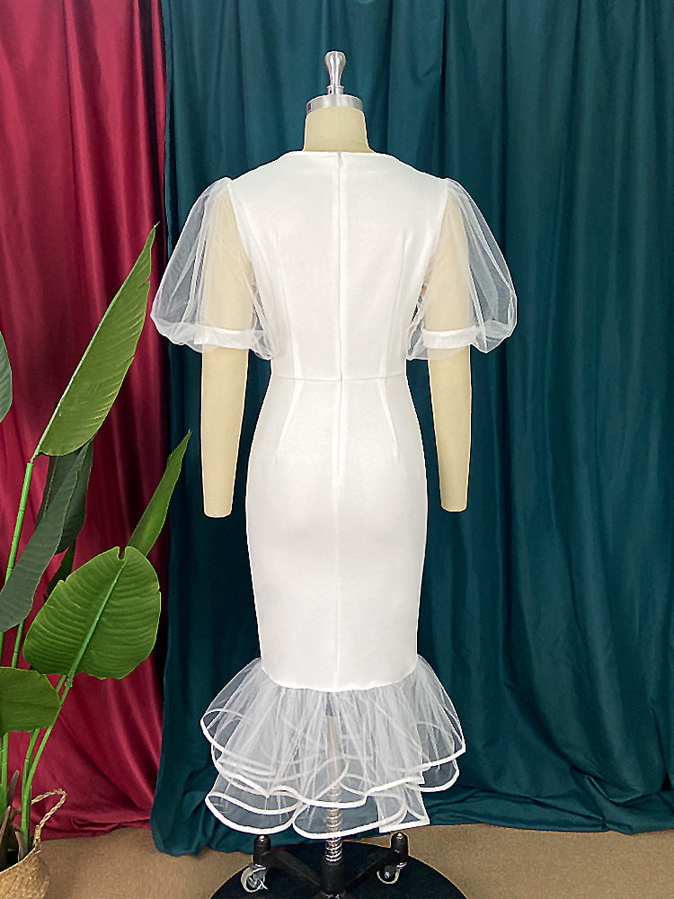 Figurbetontes, elegantes Damenkleid in Weiß mit transparenten Tüllärmeln und raffinierten Rüschen.