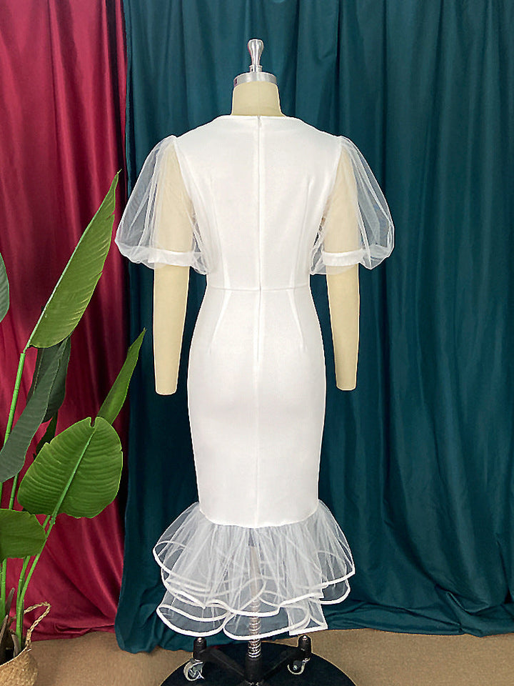 Figurbetontes, elegantes Damenkleid in Weiß mit transparenten Tüllärmeln und raffinierten Rüschen.