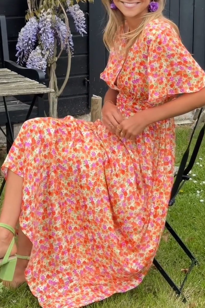Model trägt elegantes Damen Maxikleid Lyra mit floralem Design. Vielseitiges Sommer-, Party- & Urlaubskleid.