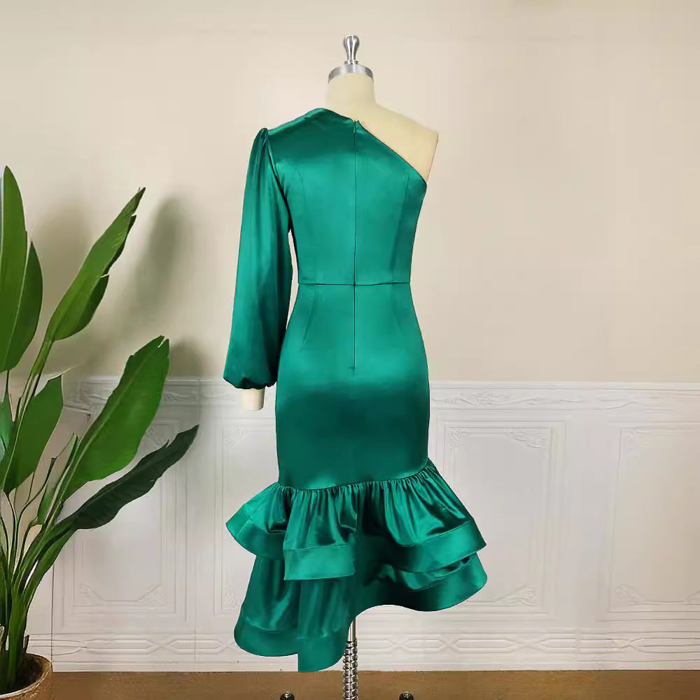 Weibliches grünes Festkleid: asymmetrisch, mit auffälligem Rüschensaum, One-Shoulder & eleganten Puffärmeln.
