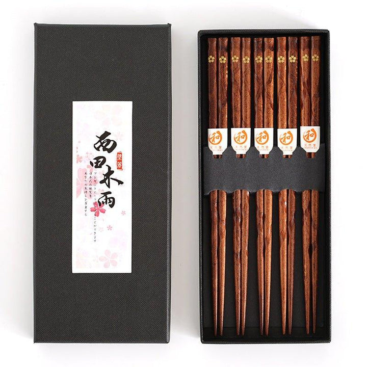 Exklusives japanisches Holz-Essstäbchen-Set mit Sakura-Gravur, ideal für ein stilvolles asiatisches Dinner.