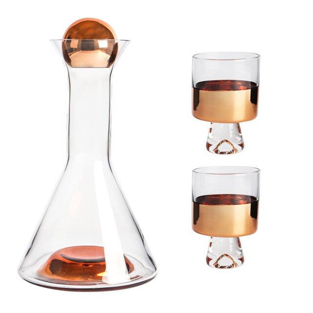 Karaffe und mehrere Gläser im nordischen Design. Rauchgraues Glas und Roségold-Akzente.