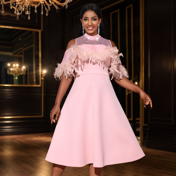 Elegantes rosa Damenkleid mit transparenten Puffärmeln und glamourösen Federdetails, perfekt für Abendveranstaltungen.
