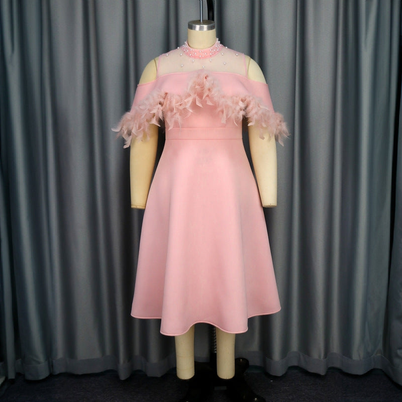 Festliches rosa Puffärmelkleid für Damen, mit zarten Federakzenten, ideal als Abend- oder Partykleid.
