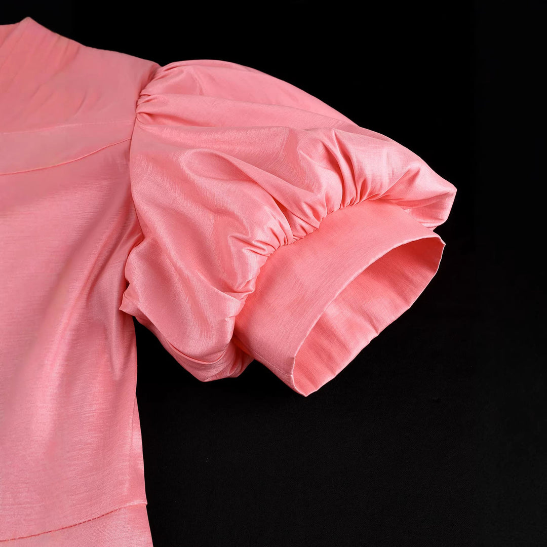 Luxuriöses Damen-Abendkleid in Rosé, mit dramatischen Puffärmeln und kunstvollen Blumenverzierungen.