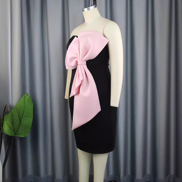 Festliches Damen Abendkleid, rosa Wickeldesign, schulterfrei, mit auffälliger großer Schleife für chicen Auftritt.