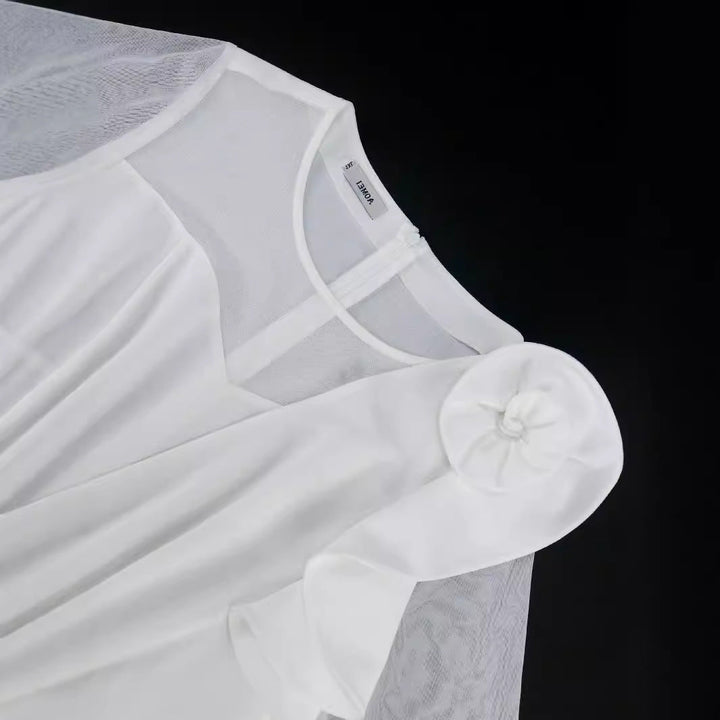 Schickes weißes Damenkleid mit eleganten Plisseefalten und feinem floralen Design, für festliche Anlässe.