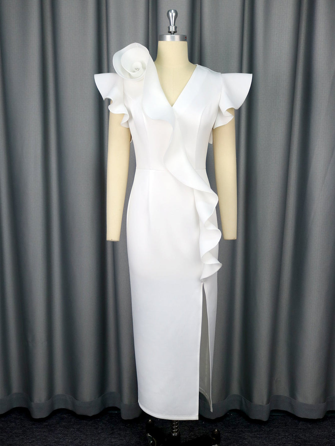 Detailansicht: Asymmetrische Rüschen am Saum eines eleganten weißen Damenkleides; vielseitig.