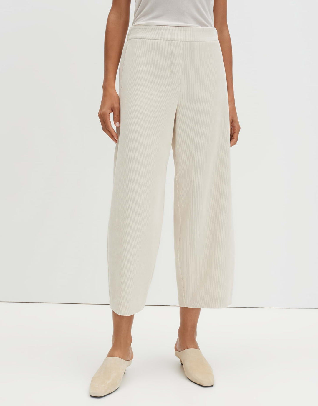Frau trägt moderne Barrel Fit Cropped Damenhose mit O-Silhouette und Mid Waist. Perfekt für einen entspannten Look.