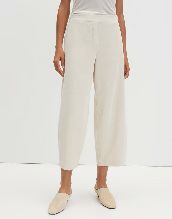 Frau trägt moderne Barrel Fit Cropped Damenhose mit O-Silhouette und Mid Waist. Perfekt für einen entspannten Look.