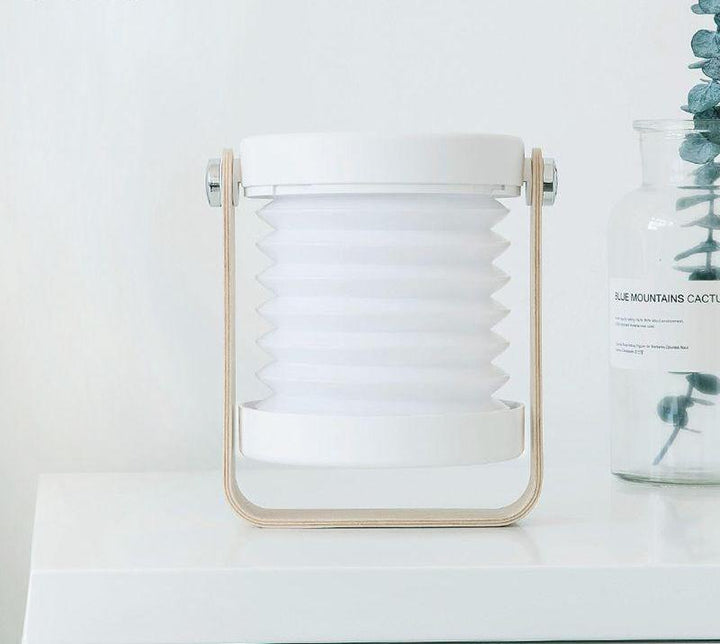 Vielseitige faltbare LED-Lampe (Grau/Weiß) mit verschiedenen Modi für Campen, Lesen oder als Notlicht.