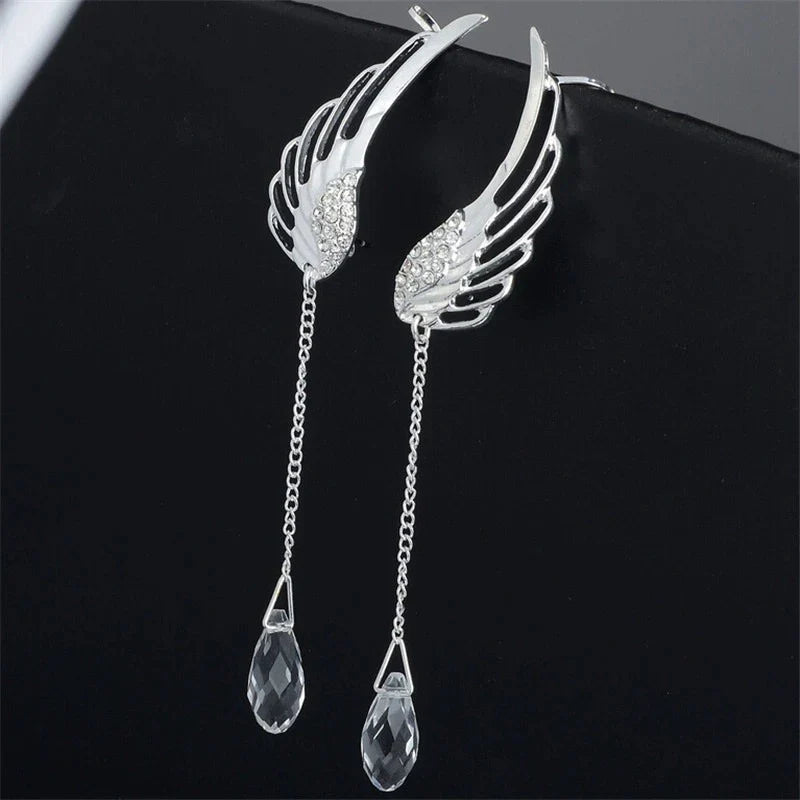 Nahaufnahme eleganter Engelsflügel Manschetten Ohrringe aus glänzendem Silberschmuck für Damen.