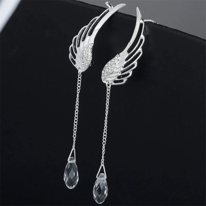 Nahaufnahme eleganter Engelsflügel Manschetten Ohrringe aus glänzendem Silberschmuck für Damen.