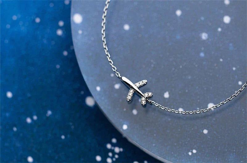 Detailaufnahme des silbernen Flugzeug-Anhängers mit Zirkon am unisex 925 Sterling Silberarmband.