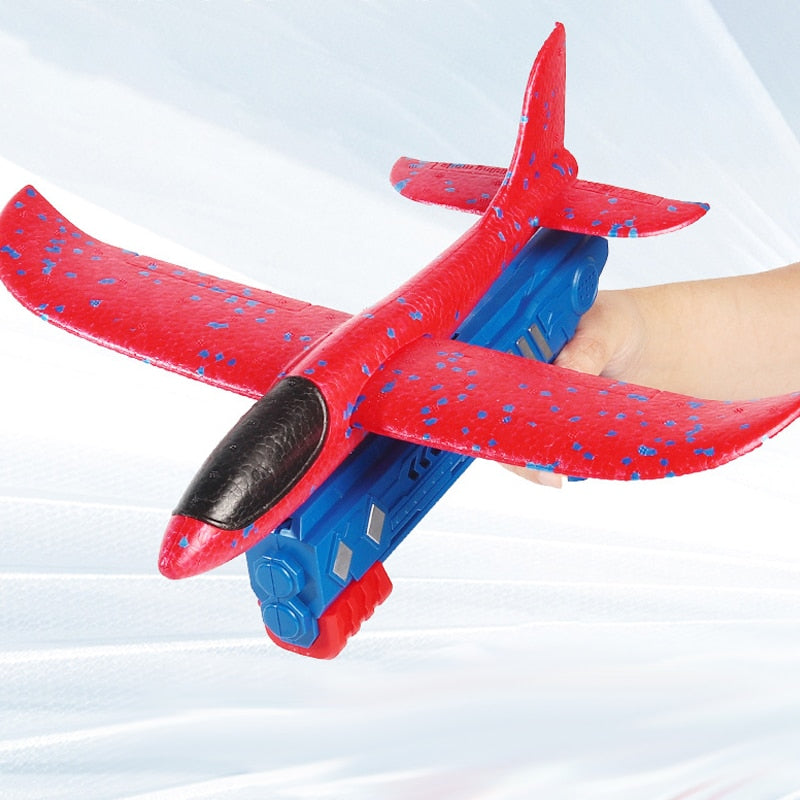 Zwei Kinder lachen beim gemeinsamen Spielen mit dem Flugzeugstarter und dem Schaumflugzeug im Garten.